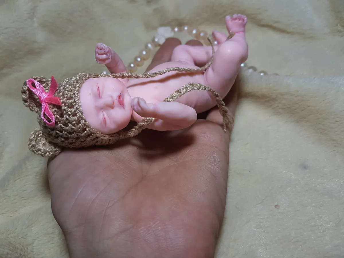 Sleeping OOAK miniature baby doll with pink bow headband and crocheted diaper, lying peacefully in palm - by Mini Baby Dolls