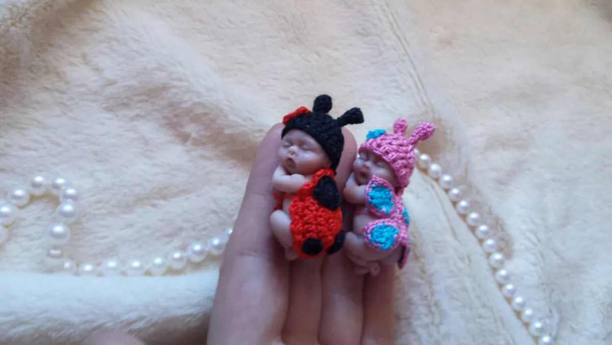 Collection of colorful OOAK miniature baby dolls in palm - ladybug, butterfly and other crocheted costumes together - by Mini Baby Dolls