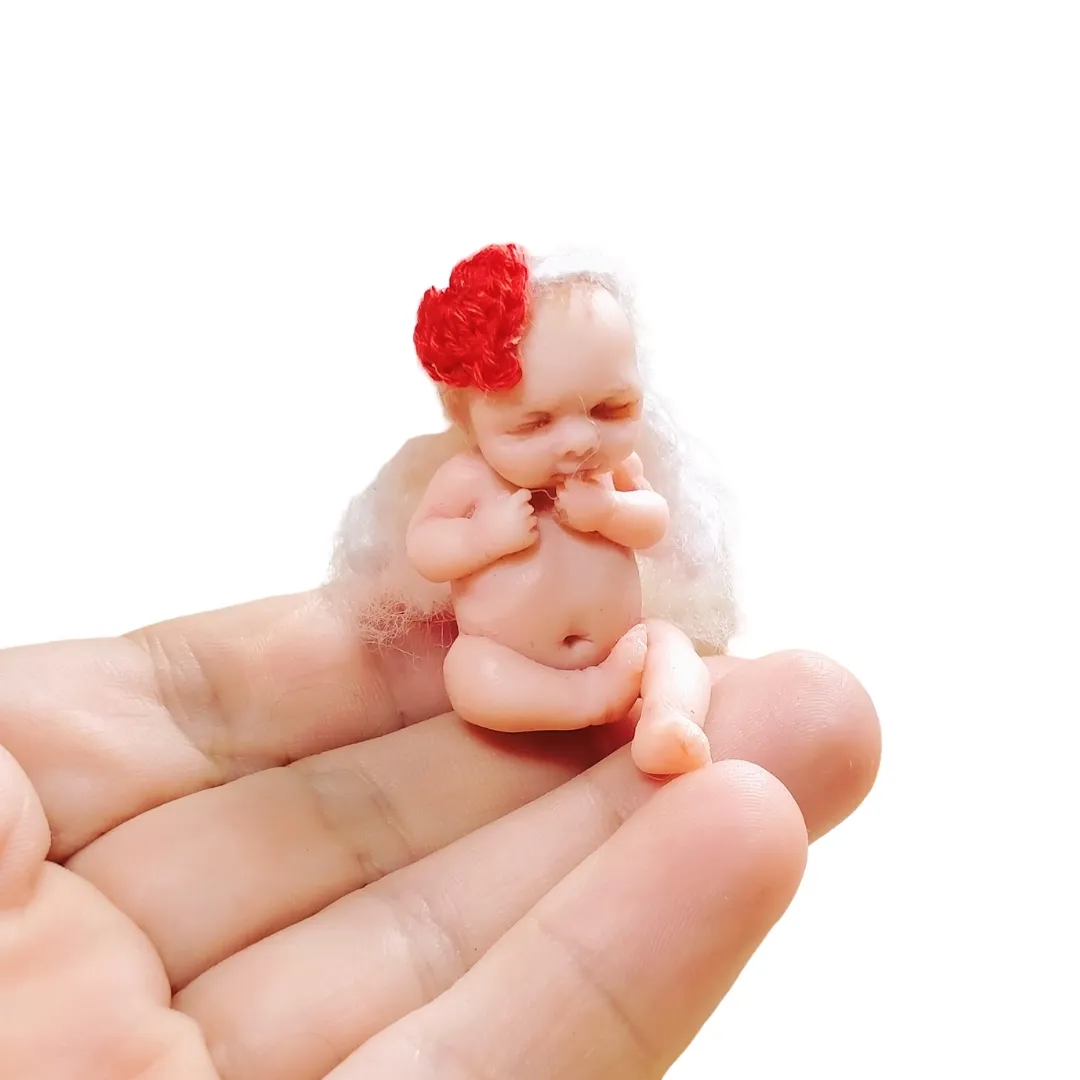 Romantic OOAK miniature Cupid angel baby doll with fluffy wings and red flower crown, held tenderly in palm - by Mini Baby Dolls