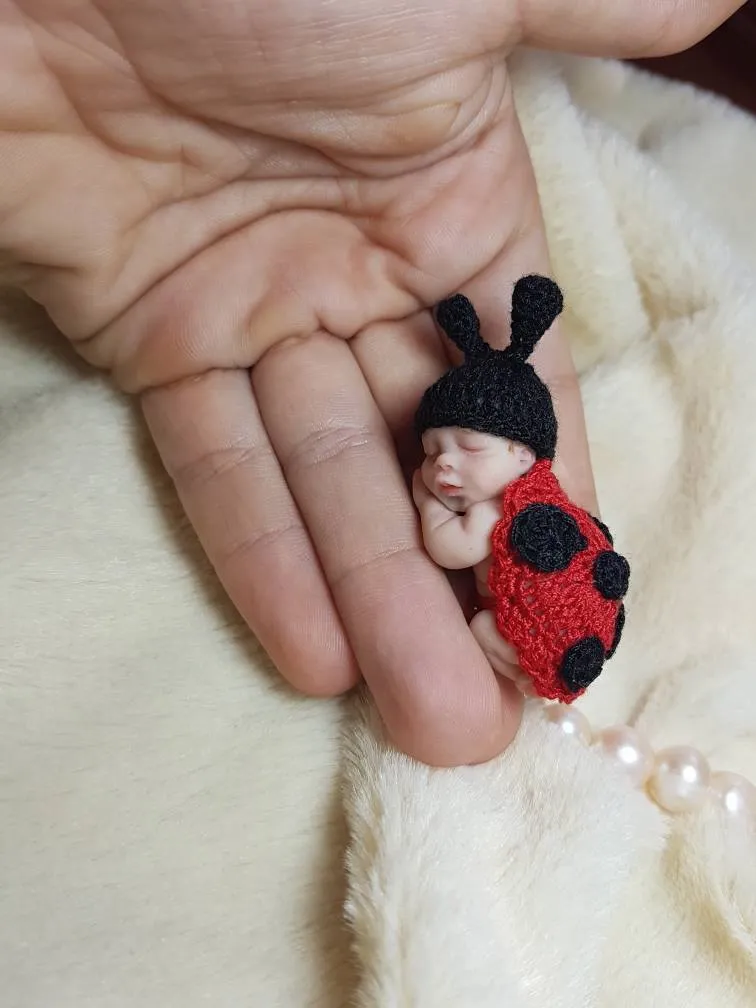 Adorable OOAK miniature baby doll in red and black crocheted ladybug costume with antennae, sleeping in palm with pearl beads - by Mini Baby Dolls