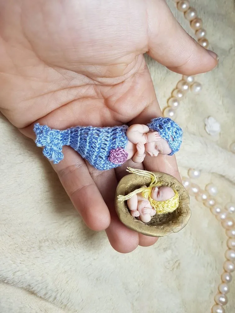 Enchanting OOAK miniature mermaid baby doll with blue crocheted tail and golden seashell, displayed in palm with tiny shell accessory - by Mini Baby Dolls