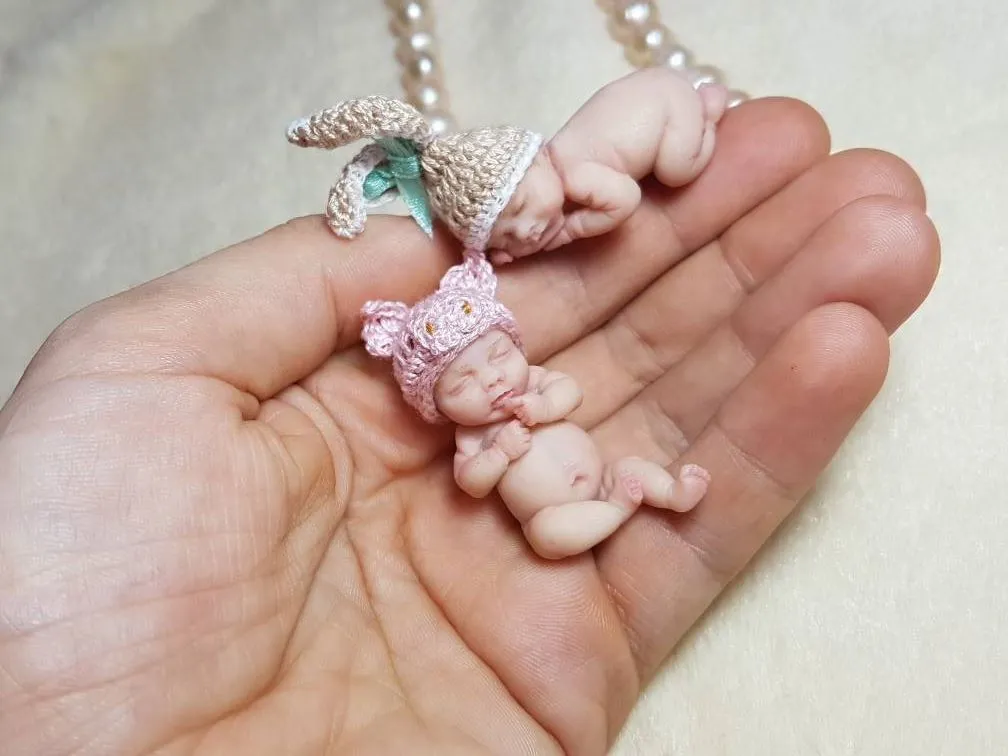 Enchanting OOAK miniature mermaid baby doll with blue crocheted tail and pink seashell top, displayed in palm with pearl beads - by Mini Baby Dolls