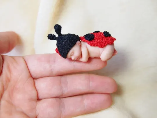 Two adorable OOAK miniature baby dolls in matching Mickey and Minnie Mouse crocheted costumes, held together in palm - by Mini Baby Dolls