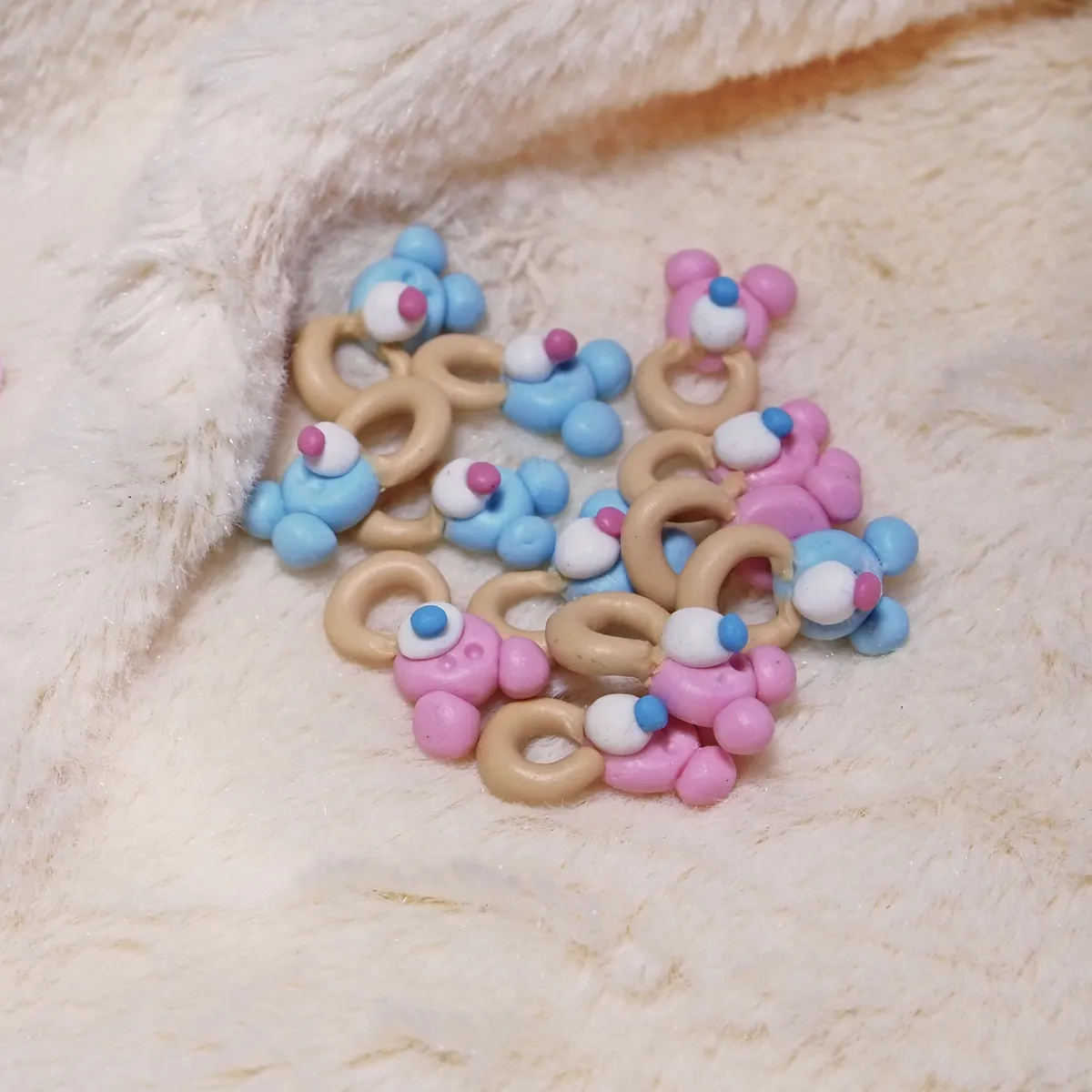 Handcrafted miniature pacifier accessories in assorted colors including pink, blue, and tan with decorative details - by Mini Baby Dolls