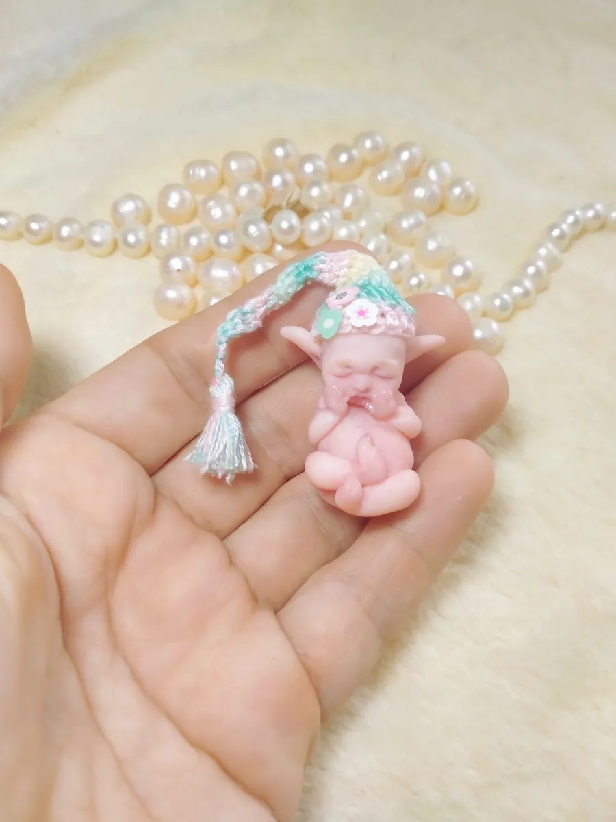 Whimsical OOAK miniature pink piglet/elf baby doll with pointy ears, wearing pastel crocheted sleeping cap with tassel - by Mini Baby Dolls