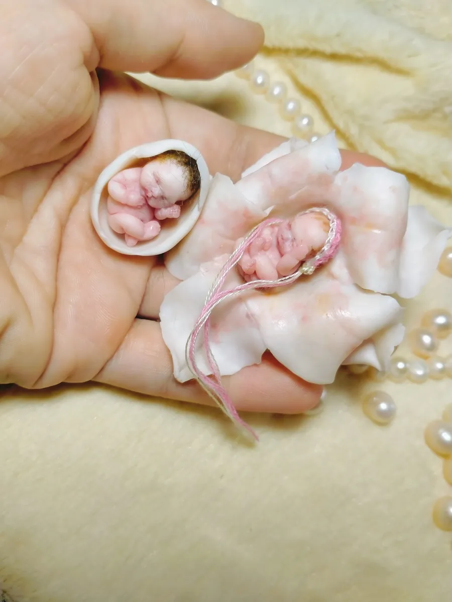 Sleeping OOAK miniature baby doll cradled in decorative seashell with pink ribbon bow, surrounded by white roses - by Mini Baby Dolls