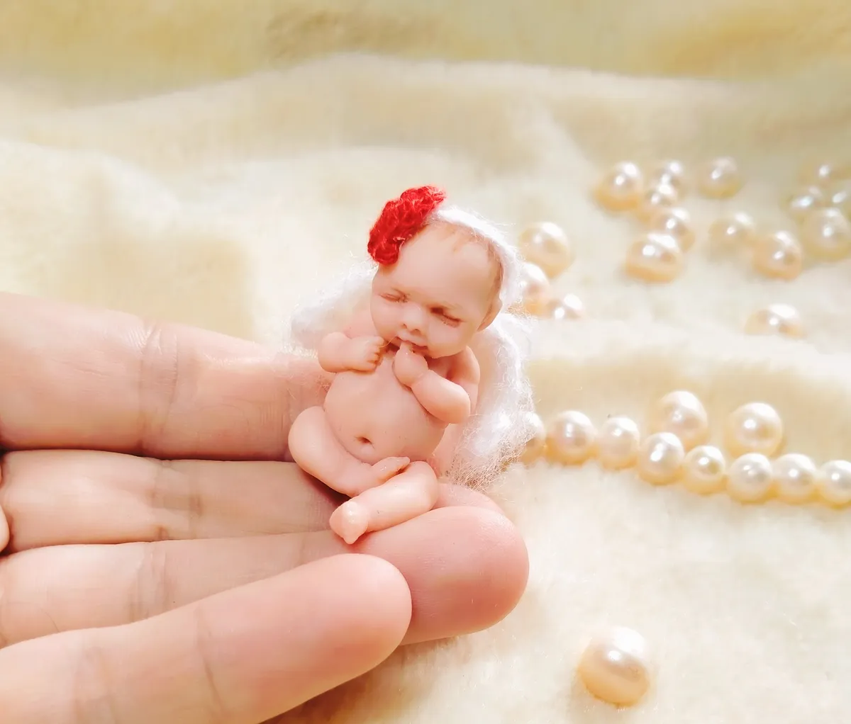 Sweet OOAK miniature baby doll in red strawberry crocheted hat, sleeping peacefully surrounded by pearl beads - by Mini Baby Dolls