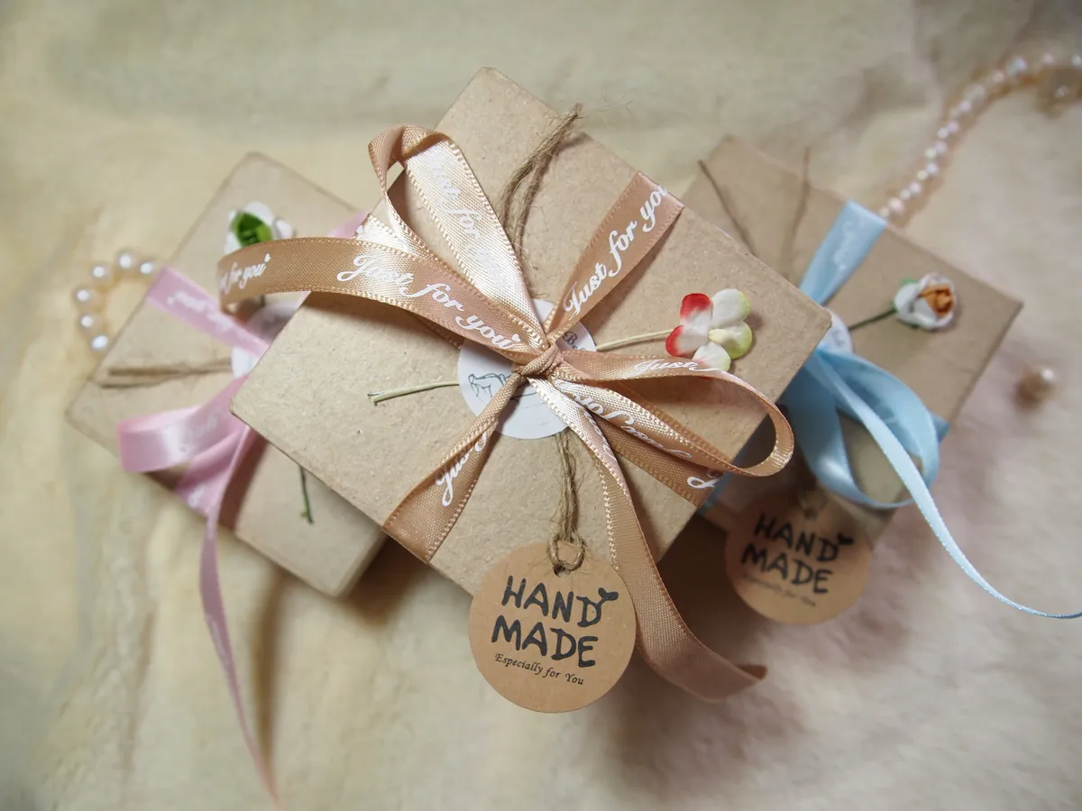 Beautifully wrapped OOAK miniature baby doll gift boxes in kraft paper with handmade tags and ribbon bows - by Mini Baby Dolls